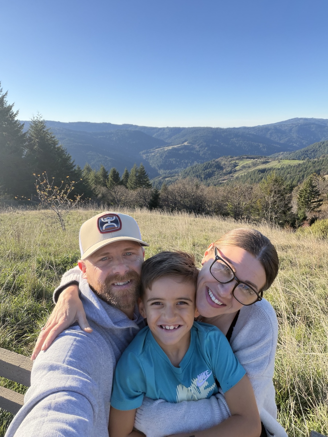 Tavi smiling with Bill and Alesha outdoors